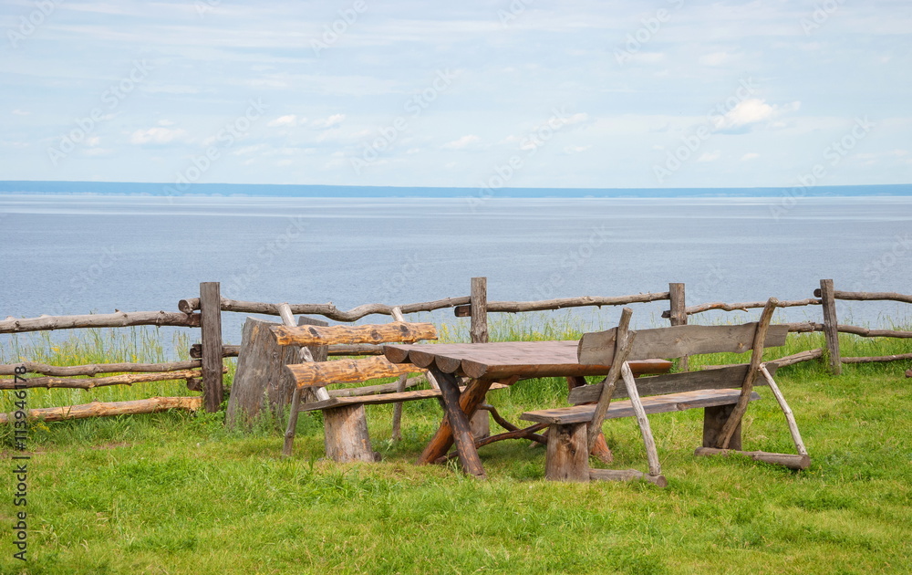 Wooden tables and benches on the bank of the river