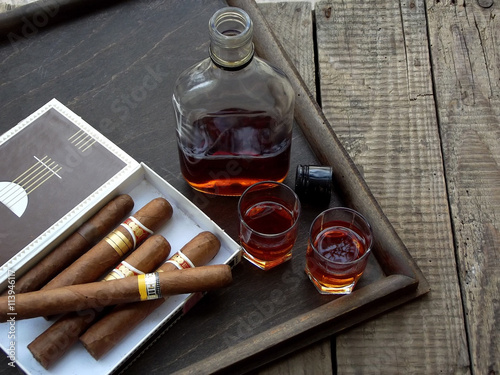 quality cigars and cognac on an old wooden table photo
