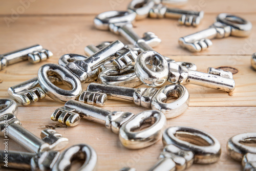 heap of silver keys on wooden floor