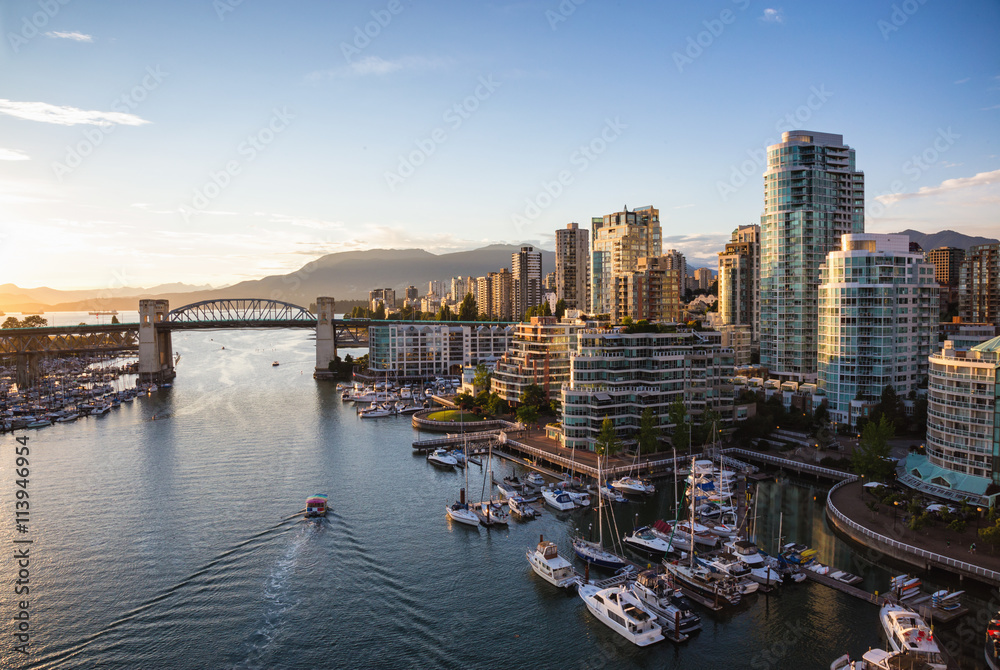 Obraz premium Widok na Downtown Vancouver i Burrard Bridge w False Creek podczas słonecznego zachodu słońca.