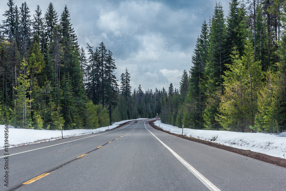 Highway running through forests of Oregon covered with snow,  USA