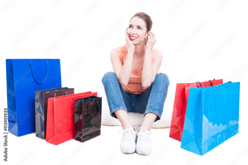 Lady shopper sitting around shopping bags and feeling pensive Lady shopper sitting around shopping bags and feeling pensive