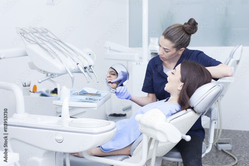 Obraz premium Beautiful woman patient having dental treatment at dentist's office. Woman visiting her dentist