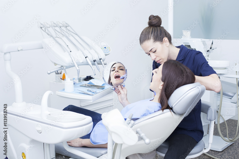 Obraz premium Beautiful woman patient having dental treatment at dentist's office. Woman visiting her dentist