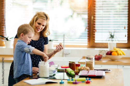 Fotografie Child helping mother bake cookies