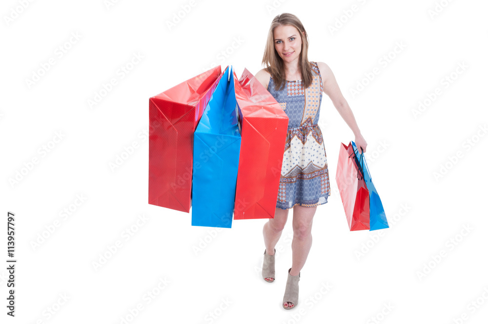 Smiling excited shopaholic woman walking with shopping bags