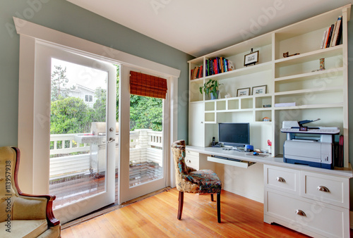 Foto Home office with white open shelves, desk and hardwood floor.