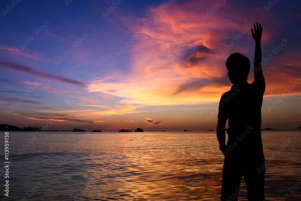 Fototapeta premium silhouette of man at sunset on the beach