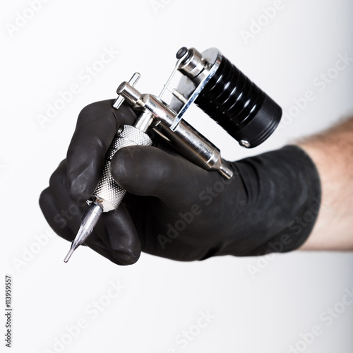 close-up of Tattooist hands in black gloves with tattoo machine