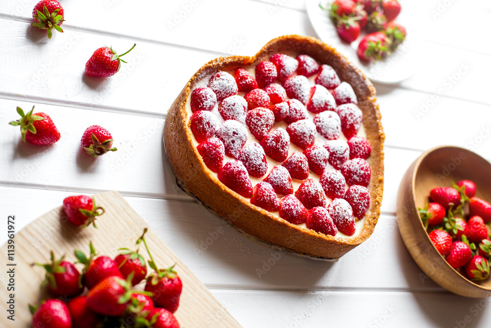 Sweet dessert on a white wooden background. Heart of strawberries Sweet dessert on a white wooden background. Heart of strawberries