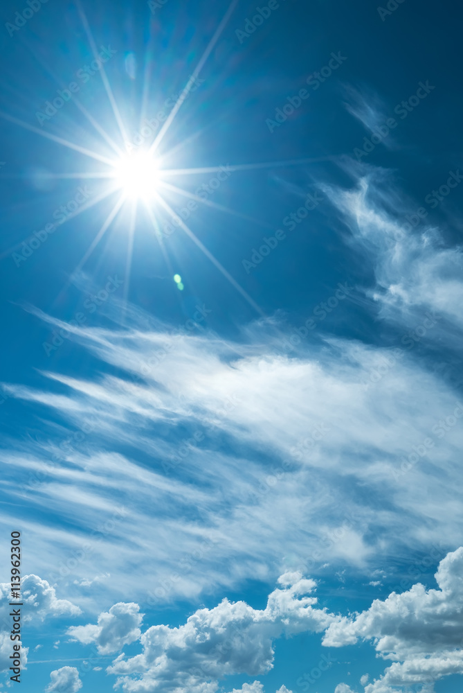 Vertical image of sky with clouds and shining sun