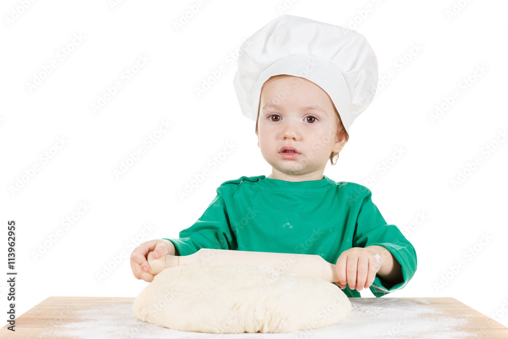 Serious little boy kneading dough for the cookies, isolated on white Serious little boy kneading dough for the cookies, isolated on white