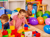 Group children game blocks on floor in nursery. Children together game.