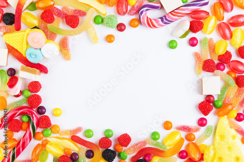 Colorful candies, jellies and lolly pops arranged as frame with copy space. Top view