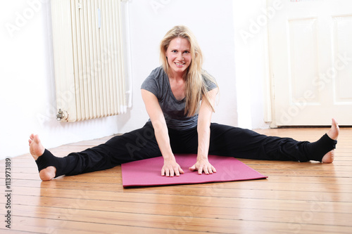 hübsche blonde Fau macht zuhause Yoga