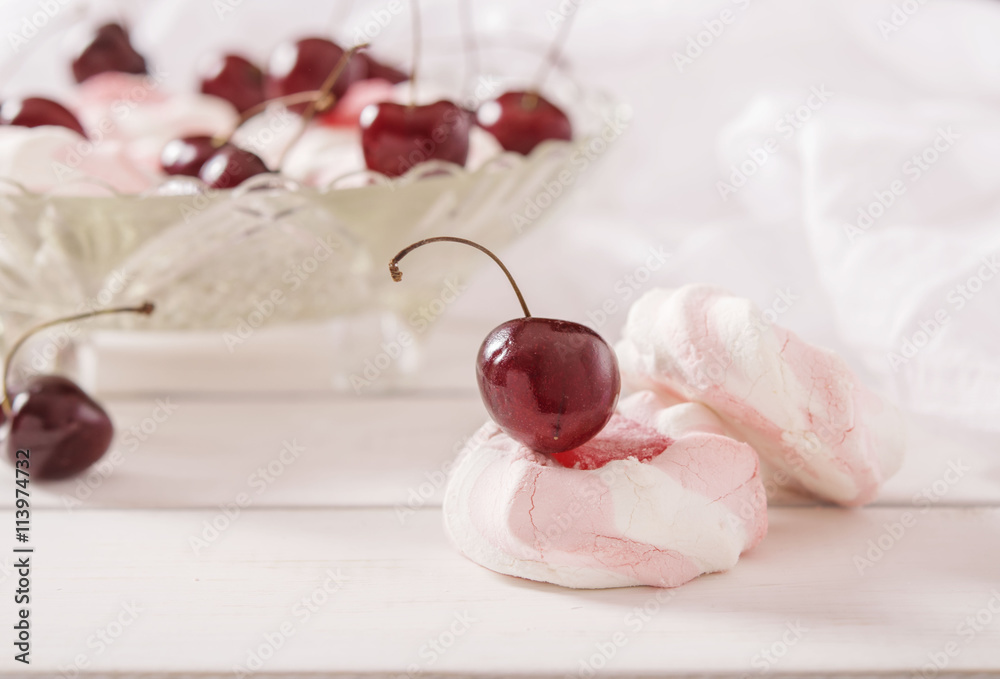 Marshmallows and cherries in a crystal vase on a white background 