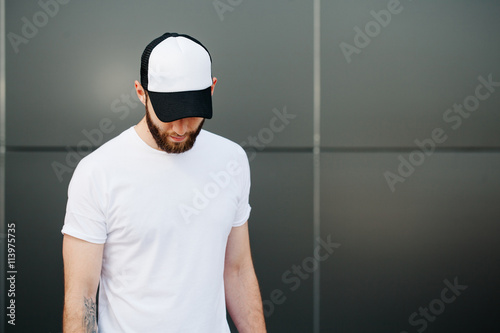 Hipster wearing white blank t-shirt and a cap with space for you photo
