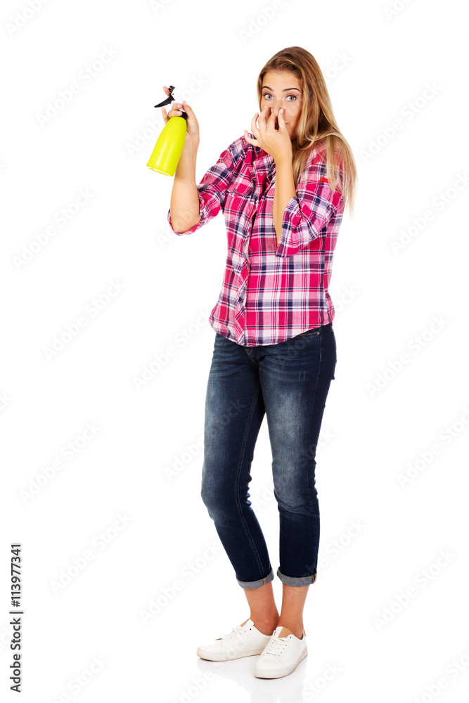 Young woman holding a watering spray bottle Young woman holding a watering spray bottle