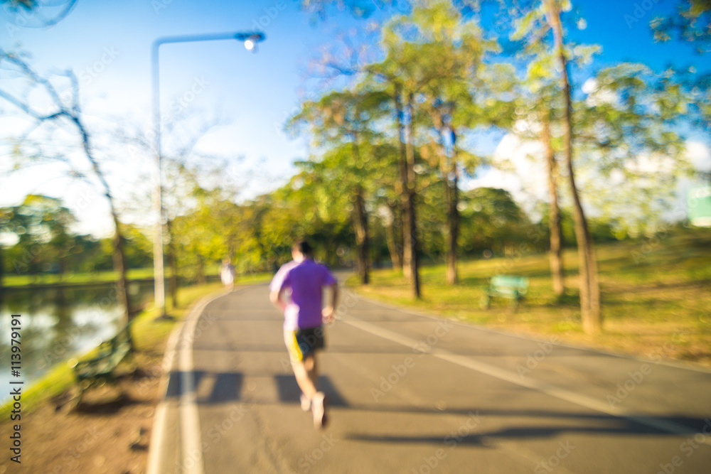 Fototapeta premium Defocused beautiful sun light at park with people exercise