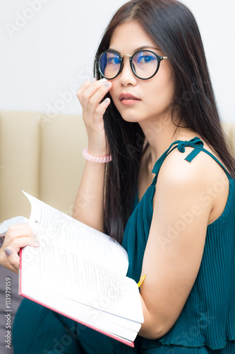 Asian girl reading book at bedroom cozy home in morning