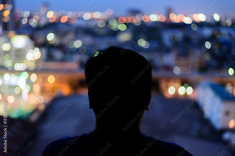Man watching the view from skyscraper. Contours of the man to background night city. Black man silhouette in the window of a skyscraper. Dark outline man watching night city. Man watching the view from skyscraper. Contours of the man to background night city. Black man silhouette in the window of a skyscraper. Dark outline man watching night city.