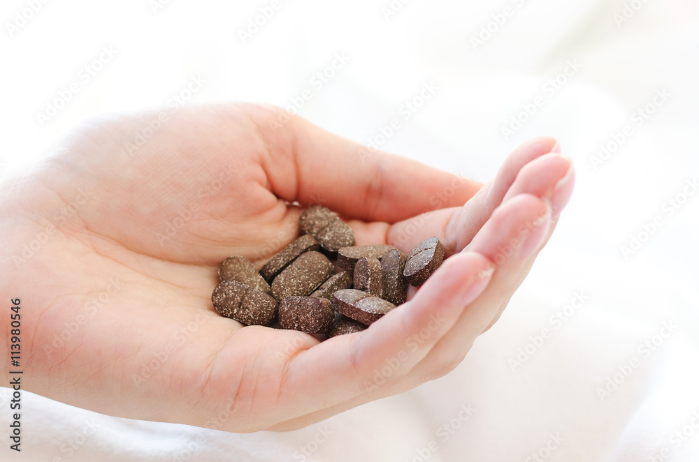 Pills in a female hand. A handful of pills on a white background Pills in a female hand. A handful of pills on a white background