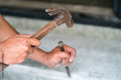 Close up on the hands of a person using a hammer
