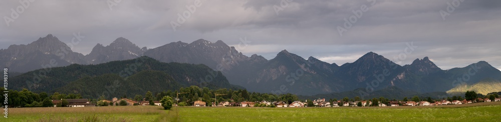 Green Valley in the German Alps with a chain of mountain peaks on the horizon. Meadow and Field in Bavaria