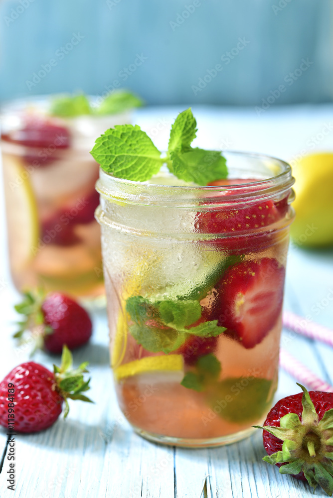 Strawberry lemonade with lemon and mint in a mason jar. Strawberry lemonade with lemon and mint in a mason jar.
