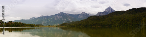 Lake in the German Alps with a chain of mountain peaks on the horizon. Reflection of the sky in water