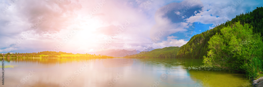 Lake in the German Alps with a chain of mountain peaks on the horizon. Sunrise or sunset Lake in the German Alps with a chain of mountain peaks on the horizon. Sunrise or sunset