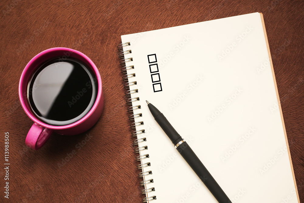 Checklist - text on notebook with a pen and cup of coffee