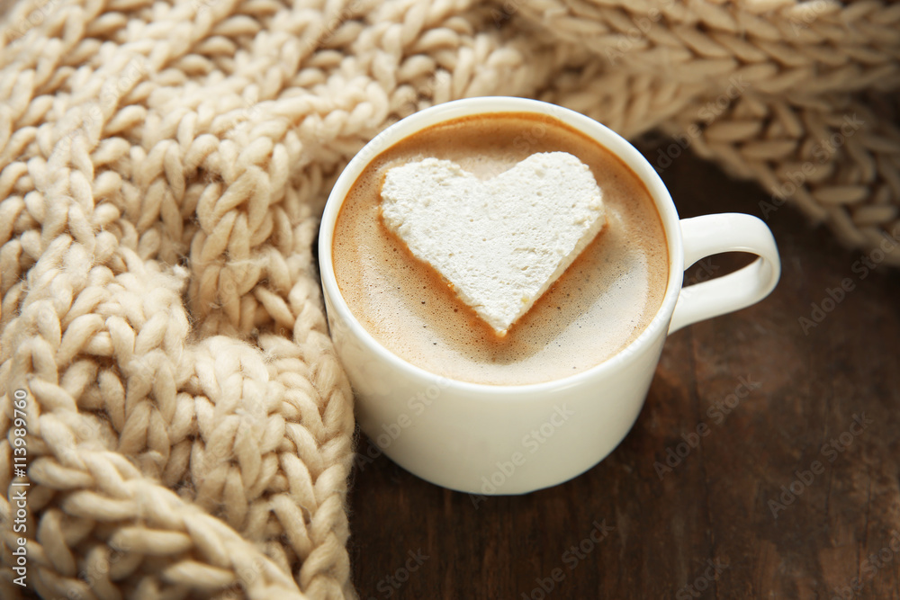 Cup of coffee with marshmallow on wooden table
