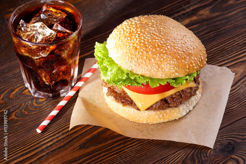 Cheeseburger and cola on texture boards. View from above.