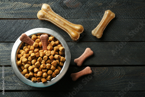 Fototapeta Naklejka Na Ścianę i Meble -  Dog food in metallic bowl on black wooden background