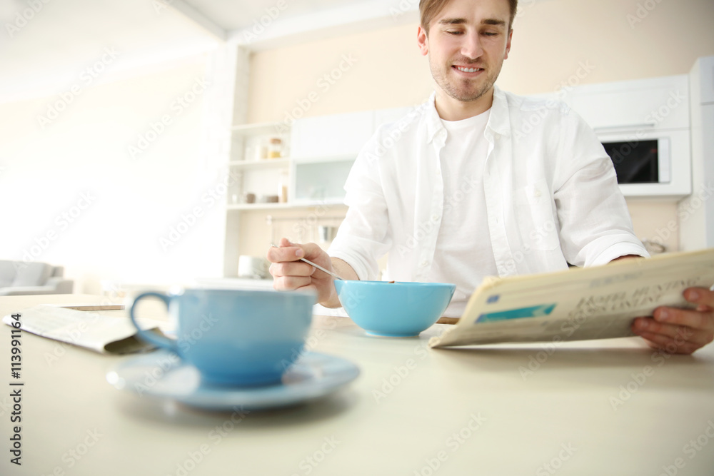Cup of coffee and man having breakfast in kitchen Cup of coffee and man having breakfast in kitchen