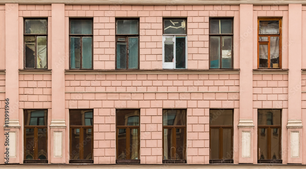 Several windows in a row on facade of urban apartment building front view, St. Petersburg, Russia.
