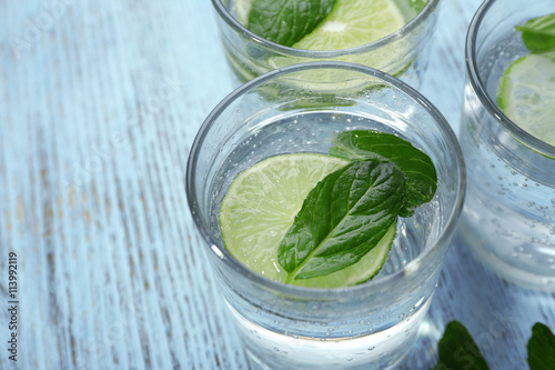 Infused lime water with mint on wooden background