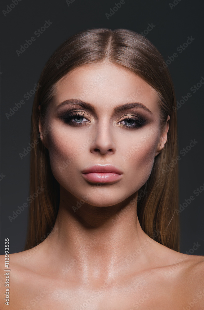 Obraz premium Beauty close-up studio portrait of a beautiful and self-confident blond girl looking straight. Vertical. Shoulders