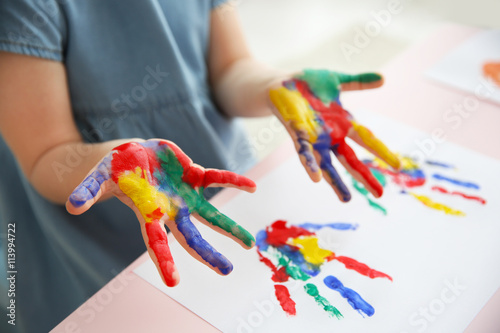 Child making hand prints on paper