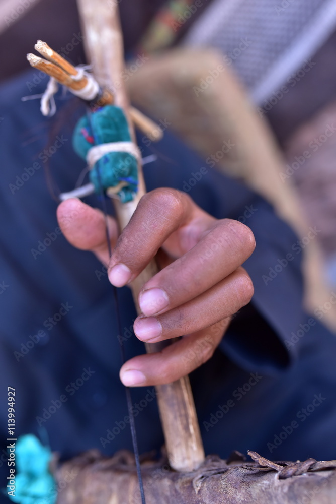 Hands of the bedouin who is performing music with his special instrument in Petra Hands of the bedouin who is performing music with his special instrument in Petra