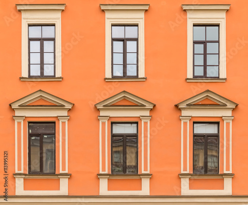 Several windows in a row on facade of urban apartment building front view, St. Petersburg, Russia.