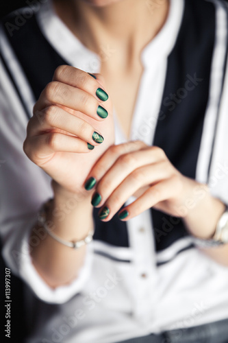 Beautiful modern fashionable girl with a green manicure. Nails style  gel.