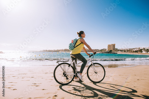 carefree woman with bicycle riding on beach sand having fun and © jul14ka