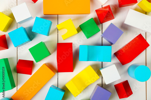 Colorful wooden children s building blocks on white wooden background