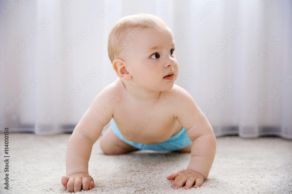 Baby boy on the floor beside window