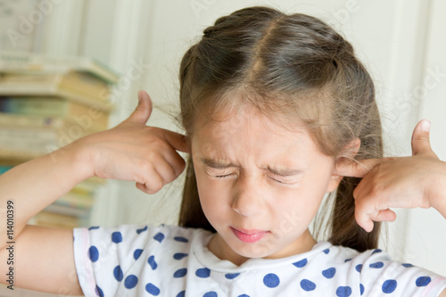 Little girl covering her ears. Negative emotion