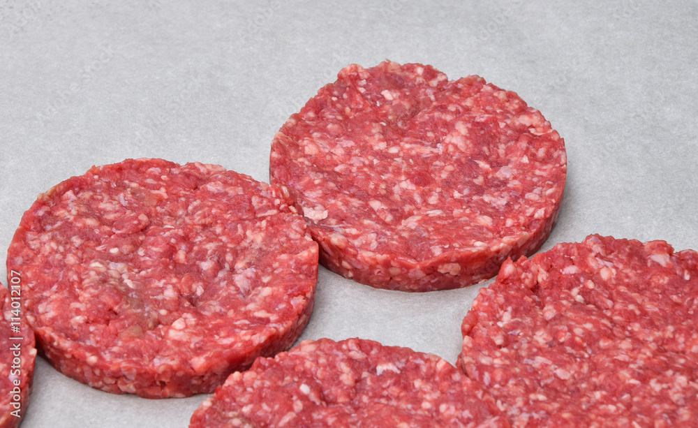 Raw meat burgers for hamburgers on parchment Raw meat burgers for hamburgers on parchment