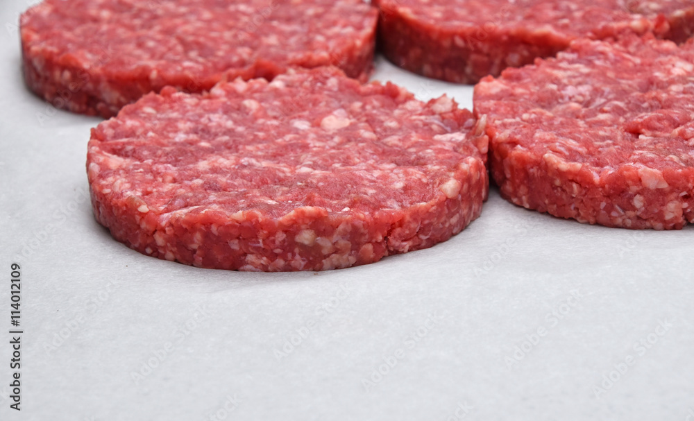 Raw meat burgers for hamburgers on parchment