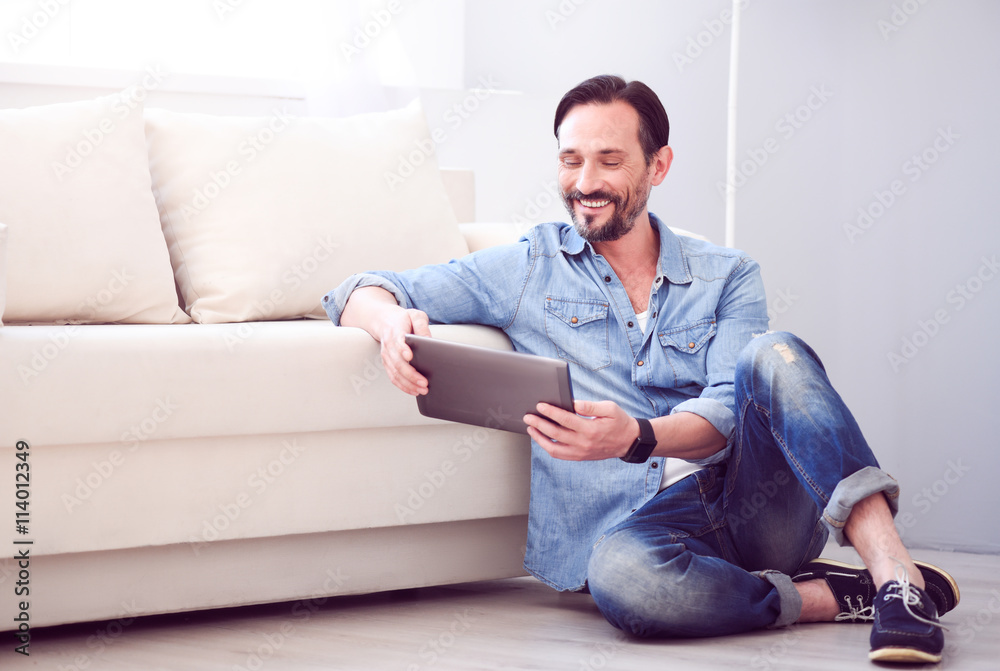 Man holding tablet and sitting on floor Man holding tablet and sitting on floor